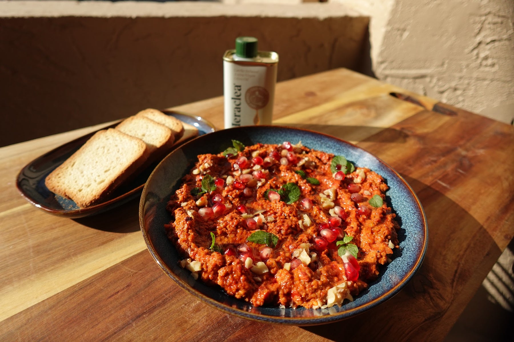 Muhammara — roasted red pepper and walnut dip drizzled with olive oil and garnished with mint, walnuts, and pomegranate seeds