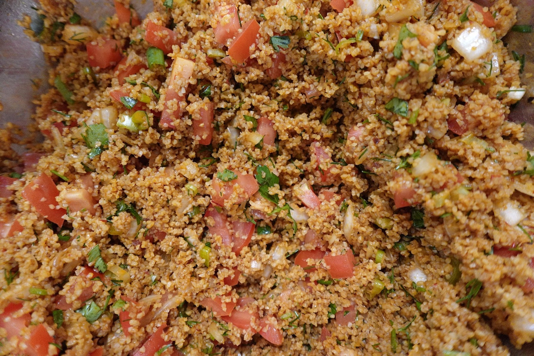 Kisir, Turkish bulgur salad with tomato and pepper paste, fresh herbs, and pomegranate molasses, served with romaine lettuce leaves and lemon wedges